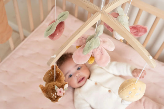 Neonata distesa che osserva una giostrina rosa Little Dutch, ideale per stimolare la vista e accompagnare la nanna con dolcezza