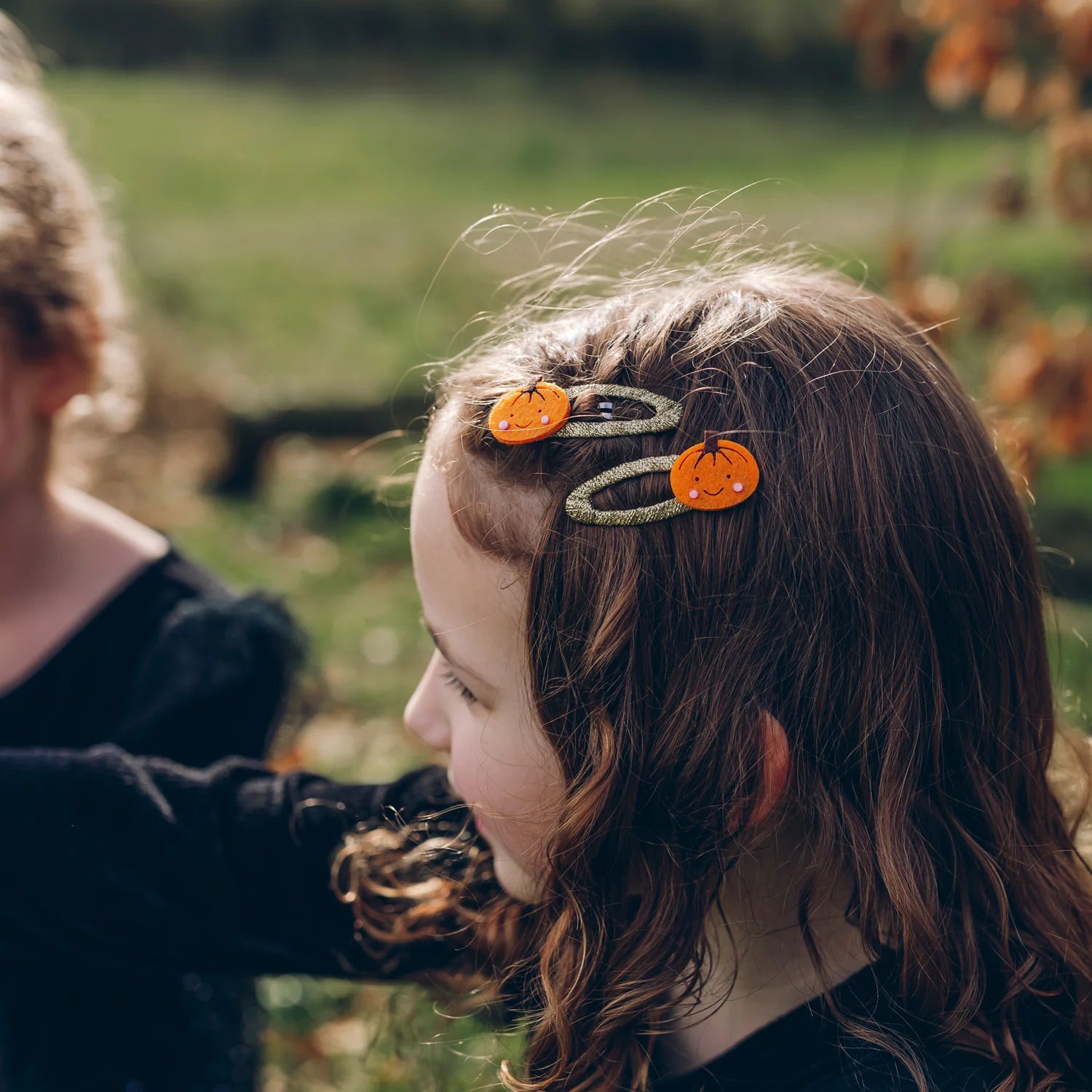 Bambina con fermagli Rockahula Little Pumpkin Clips nei capelli durante la festa di Halloween