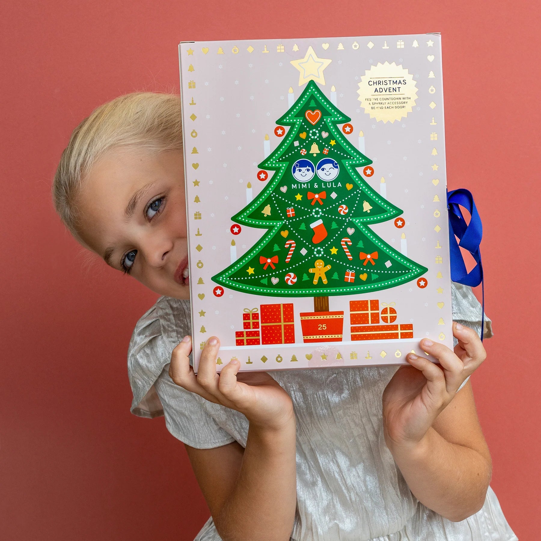Bambina che apre il calendario dell’Avvento Mimi & Lula con accessori natalizi