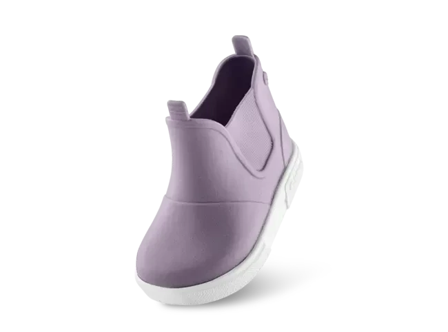 Bambino indossa stivaletti Boatilus Baby Beatly lilla e bianco in giornata di pioggia