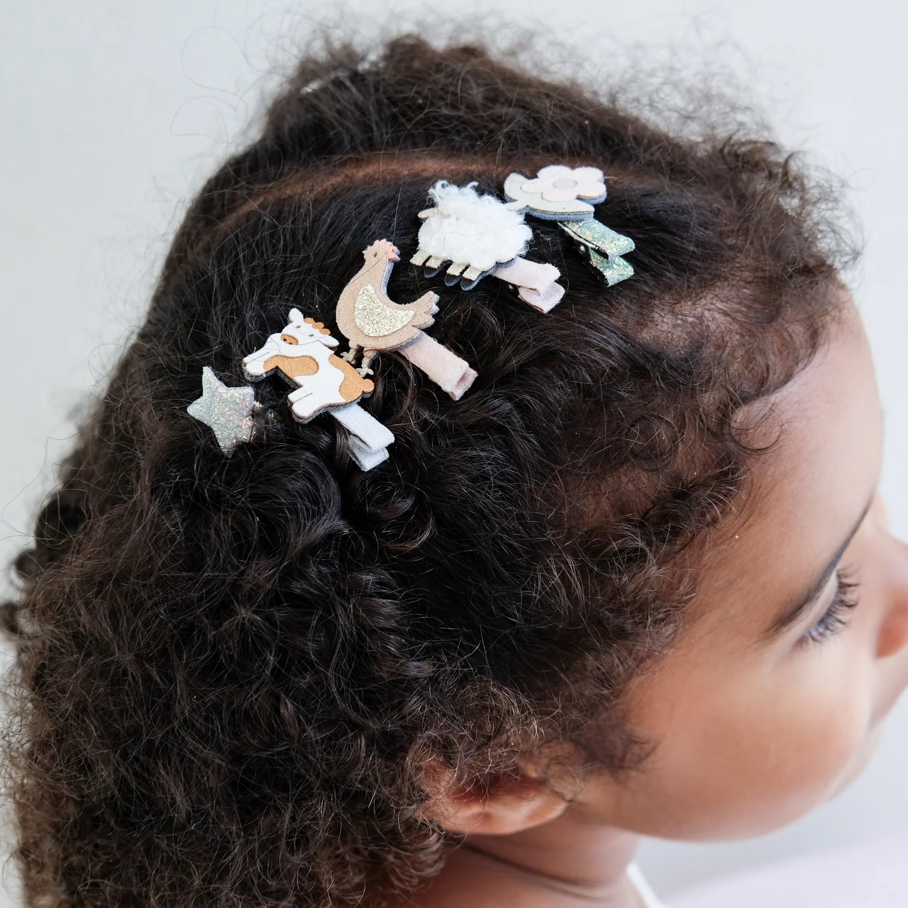Bambina con fermagli Mimi & Lula a tema animali della fattoria nei capelli