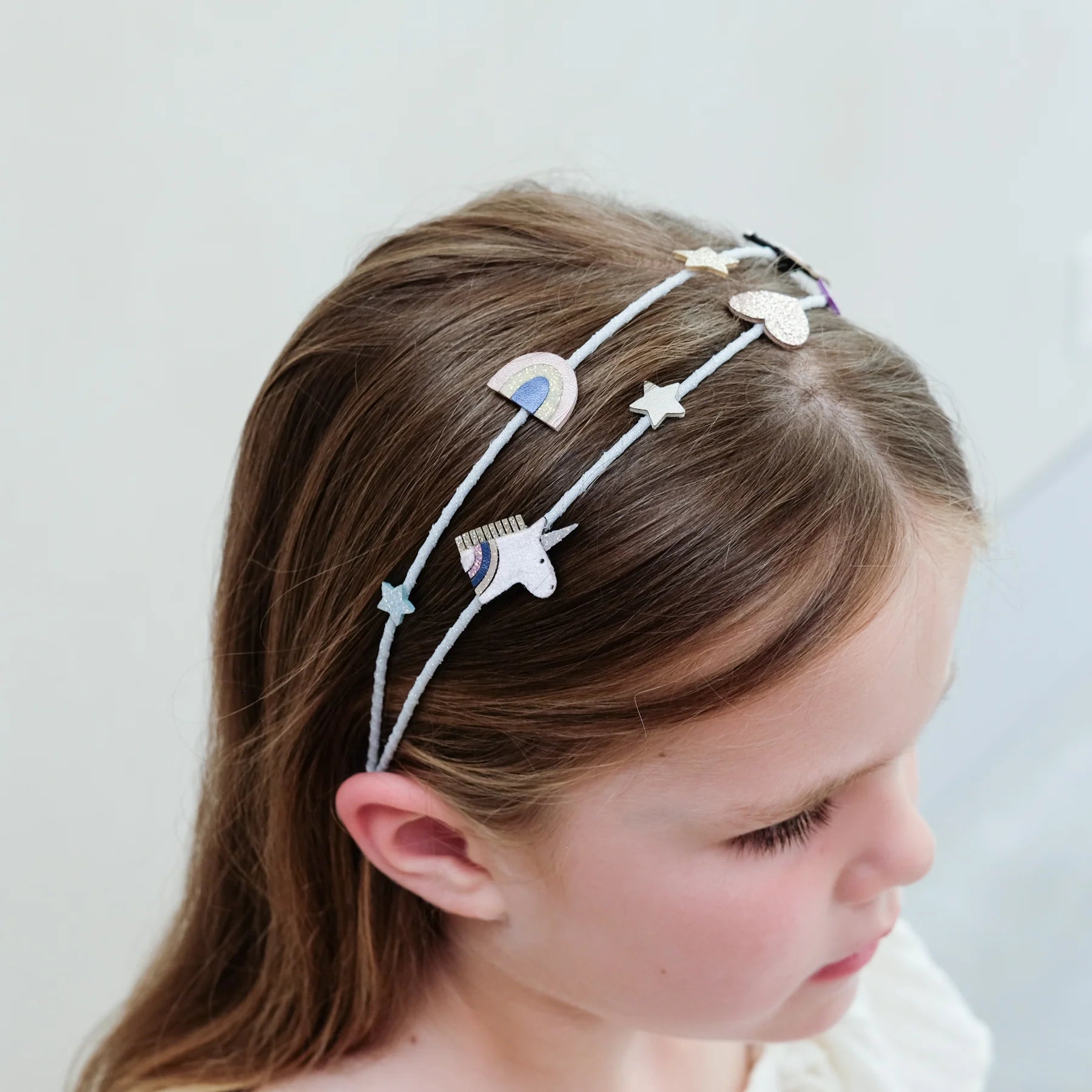 Bambina con cerchietto doppio Mimi & Lula Celeste Unicorn decorato con unicorni e arcobaleni