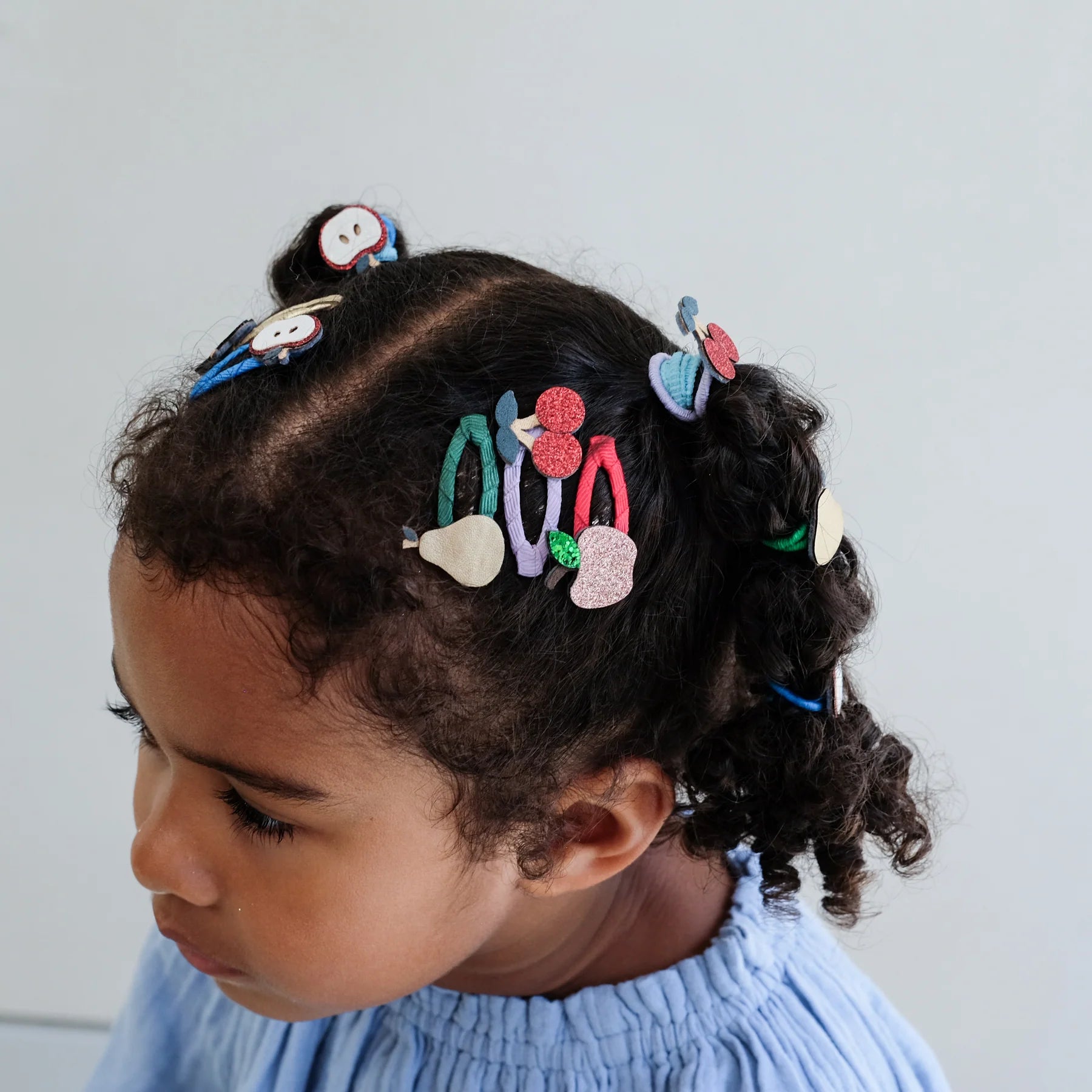 Bambina che indossa le mollette capelli Mimi & Lula Fruity Mini Clic Clacs con frutti colorati