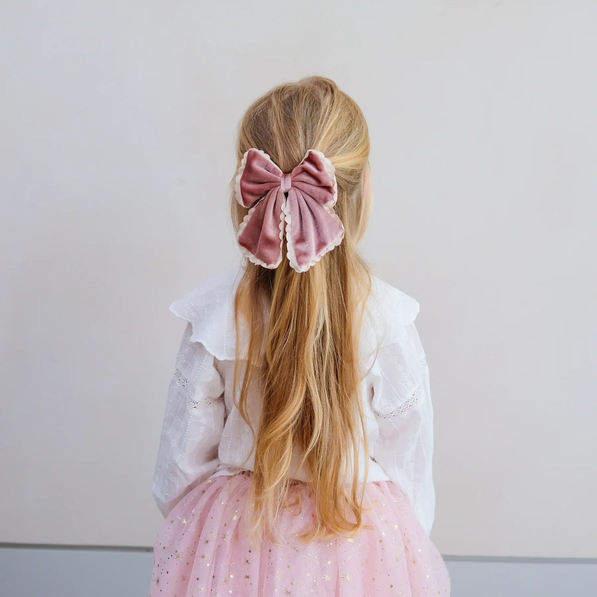 Bambina con maxi fiocco rosa in velluto Mimi & Lula