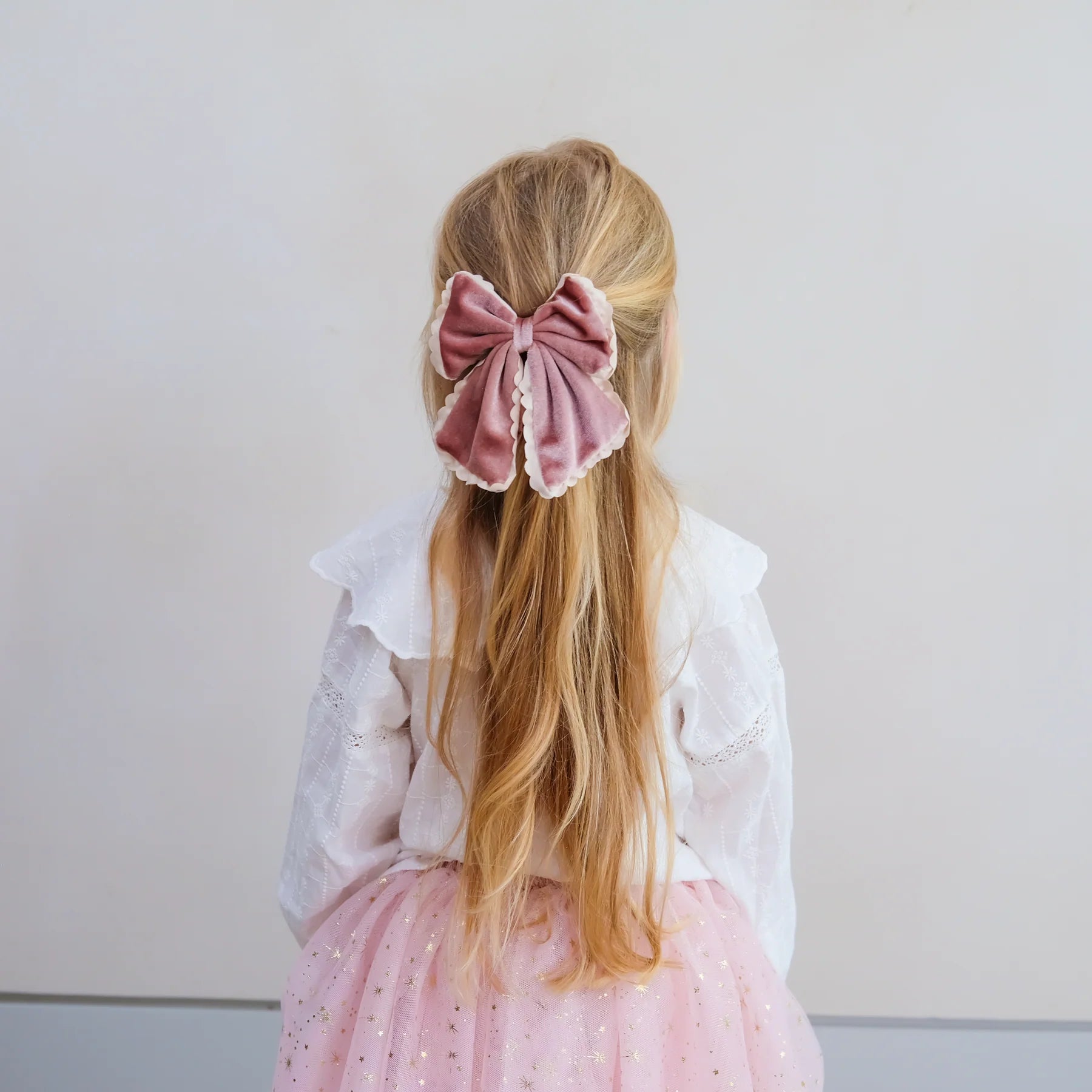 Bambina con maxi fiocco rosa in velluto Mimi & Lula
