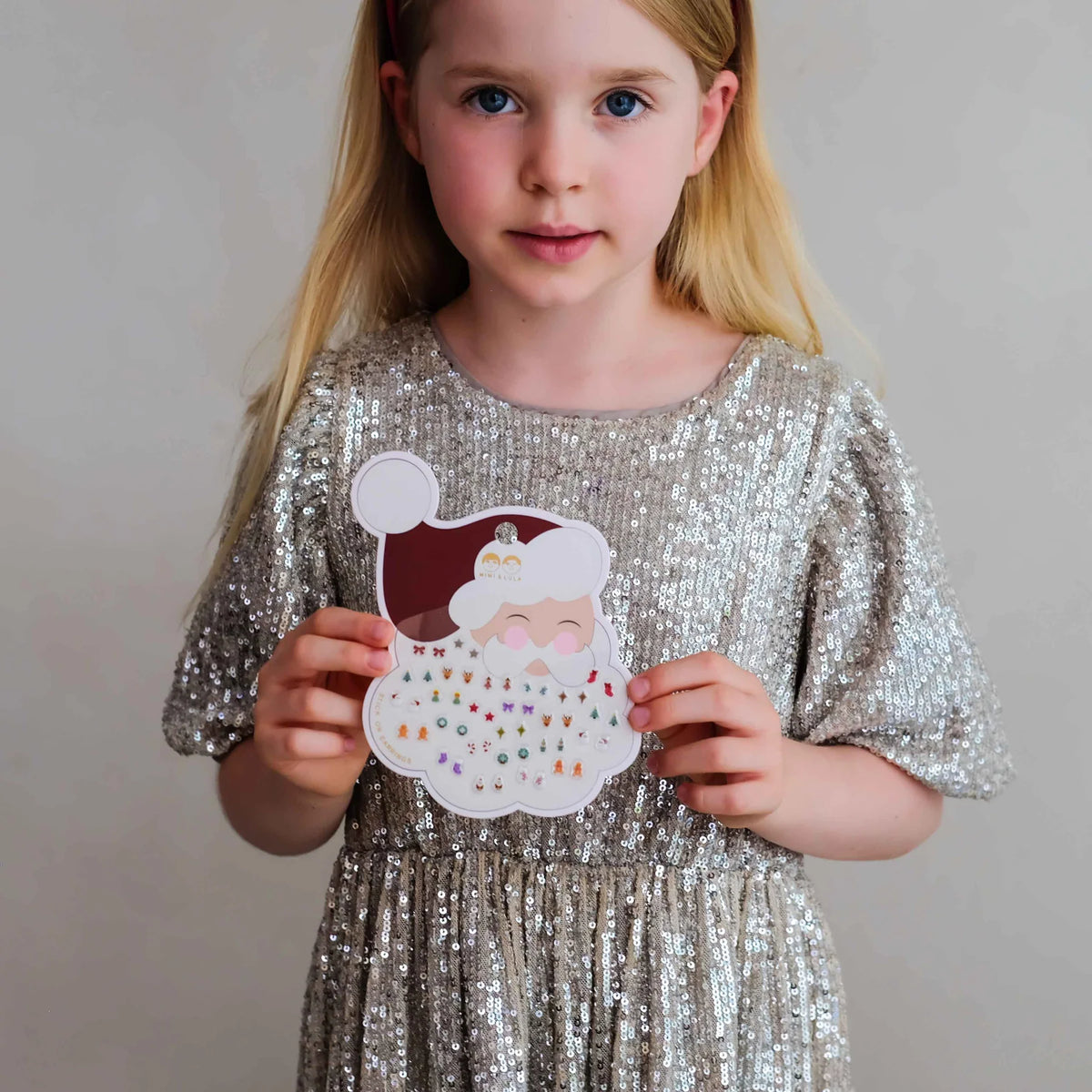Bambina con orecchini adesivi natalizi Mimi & Lula senza buchi alle orecchie
