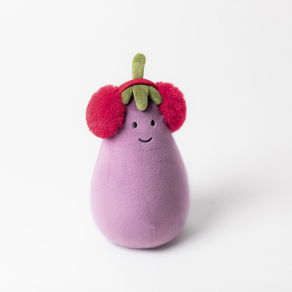 Peluche Jellycat melanzana con cuffie rosse su fondo invernale, idea regalo originale