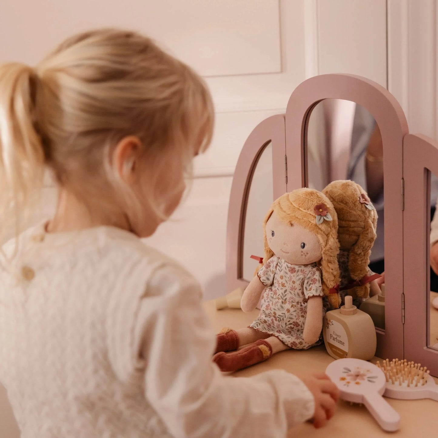 Bambina che gioca con bambola Julia Little Dutch davanti allo specchio