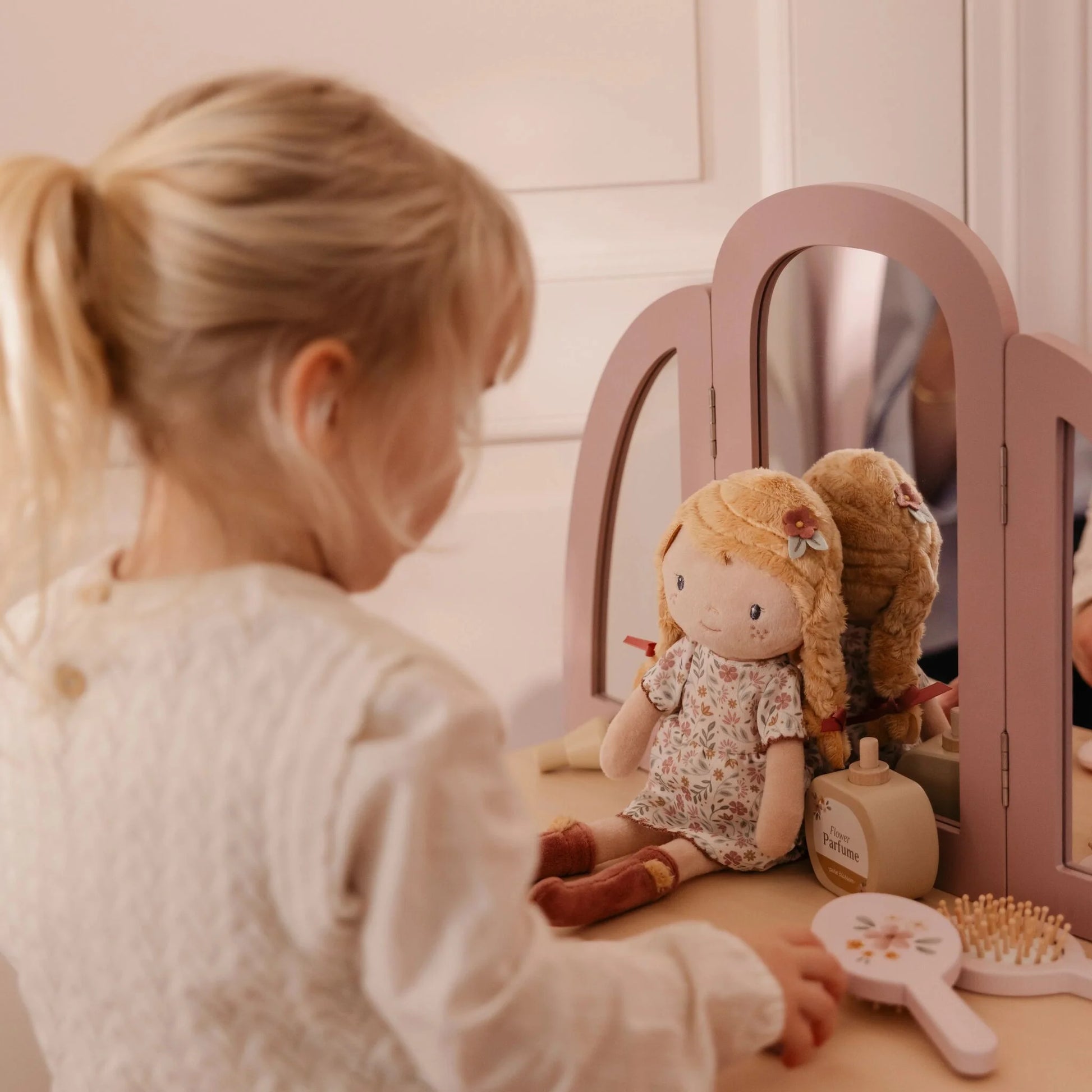 Bambina che gioca con bambola Julia Little Dutch davanti allo specchio