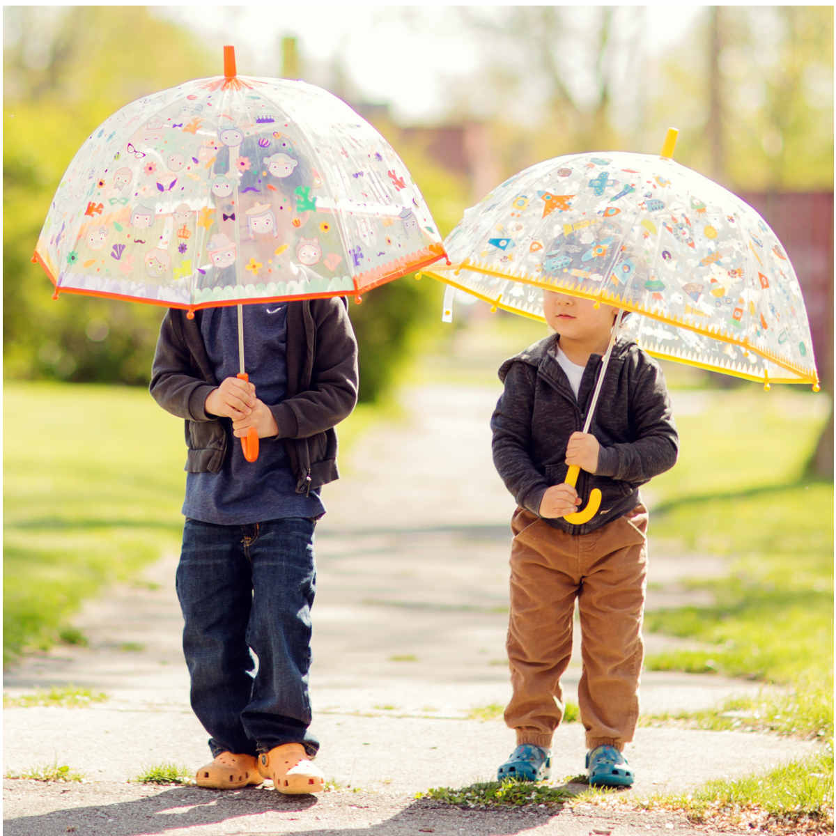 Bambini che giocano sotto la pioggia con gli ombrelli Djeco cambia colore – collezione Facce
