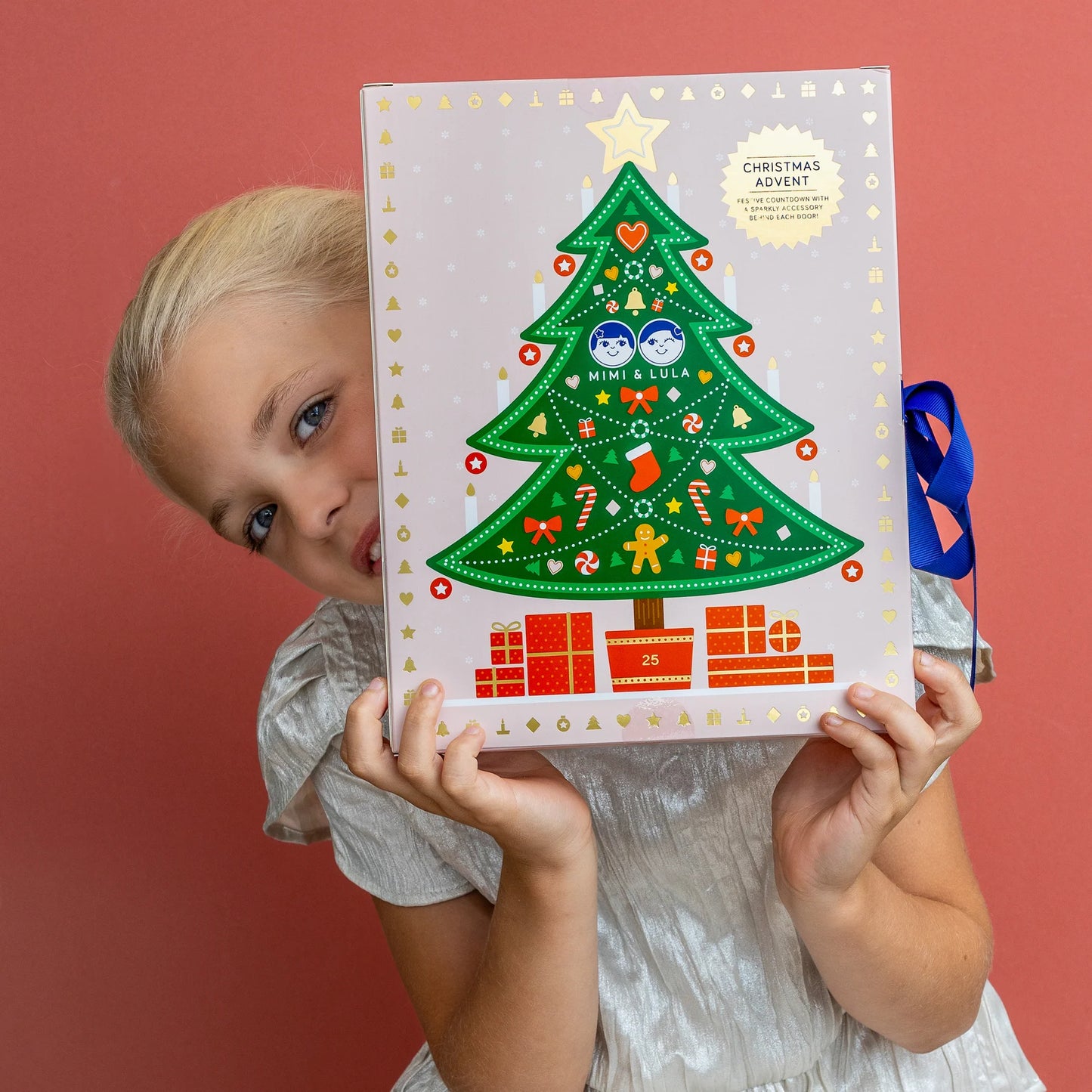 Bambina che apre il calendario dell’Avvento Mimi & Lula con accessori natalizi
