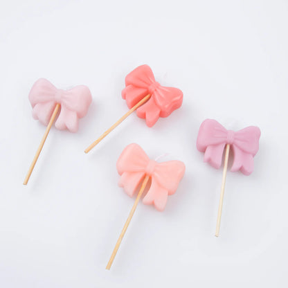 Set di 4 candele Meri Meri a forma di fiocco rosa per decorare torte da festa