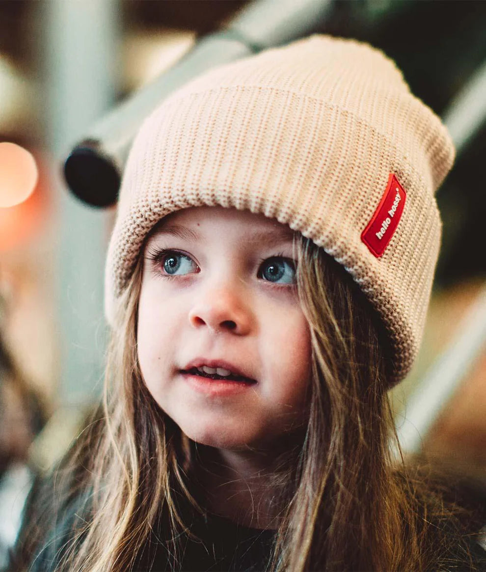Bambino con cappellino neutro Hello Hossy Flow Creamy durante una passeggiata