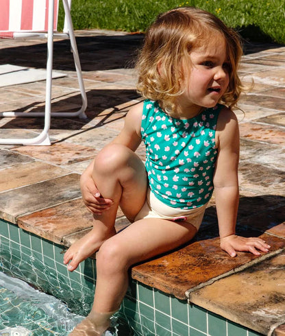 Bambina che indossa il costume Hello Hossy Garden Joy al mare