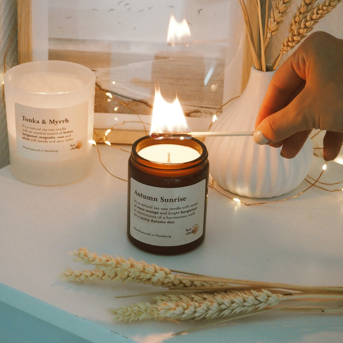 Candela Hey Chalky Autumn Sunrise accesa su tavolo con atmosfera autunnale e luce calda