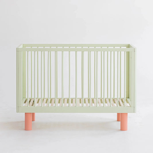 Karl & Fric NOX Cot Pistachio & Pink, lettino evolutivo in legno massiccio di betulla con kit junior incluso e finitura verde pistacchio e rosa.