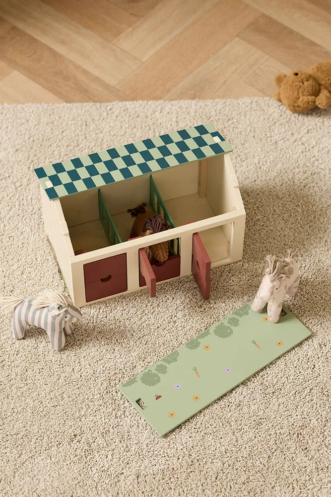 Bambini che giocano con la stalla Kid’s Concept con 3 box e tetto reversibile prato fiorito