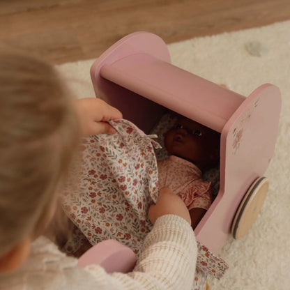 Bambina gioca con il passeggino in legno rosa Little Dutch