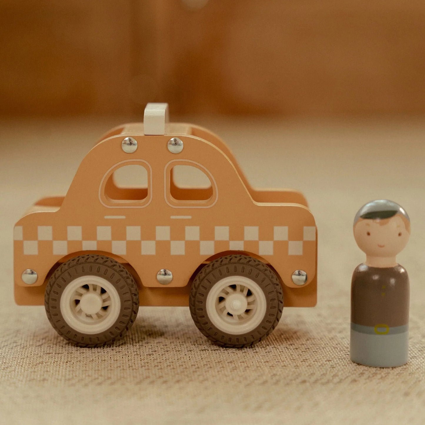 Bambino che gioca con la taxi in legno gialla Little Dutch su un tappeto