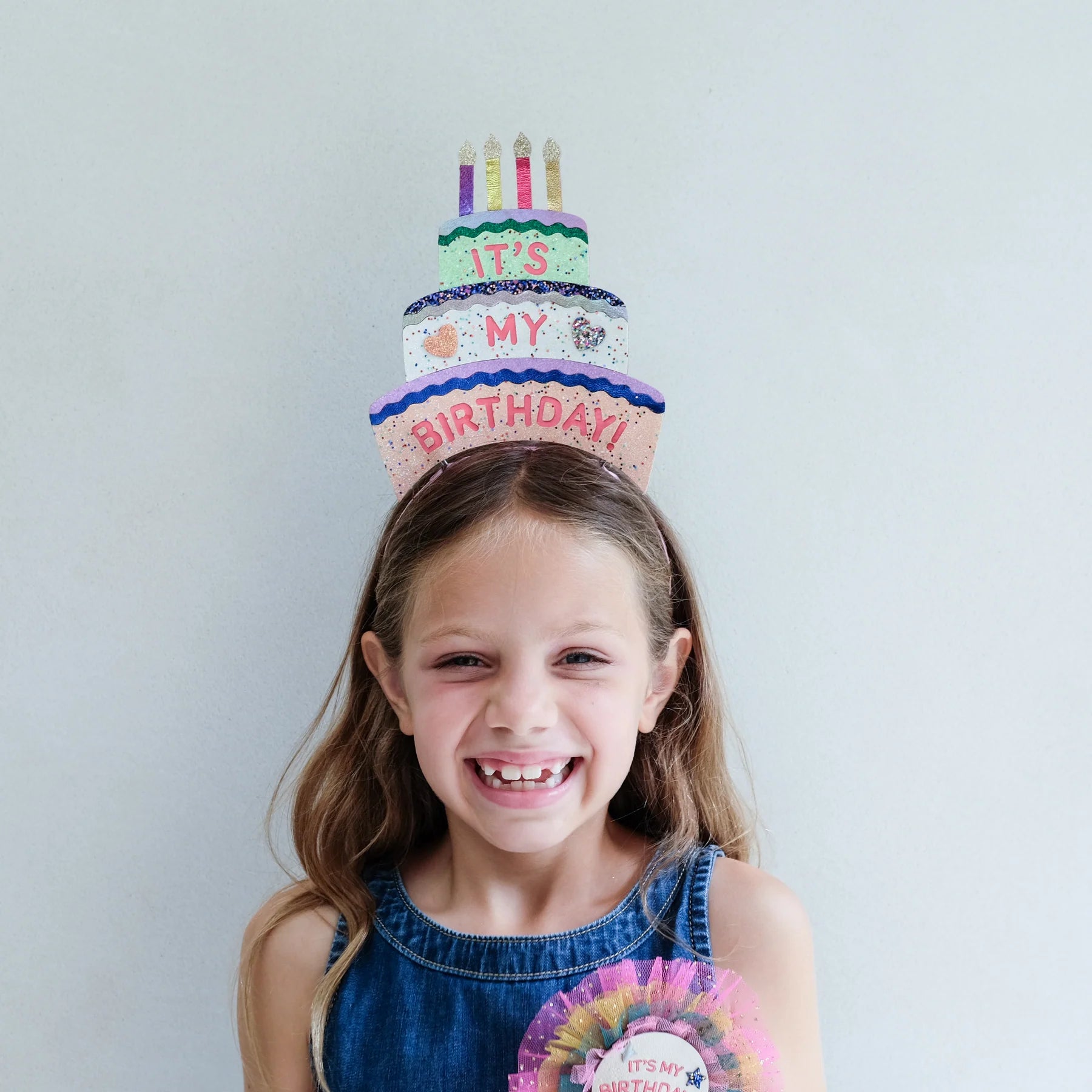Bambina che indossa il cerchietto compleanno Mimi & Lula Birthday Cake Headdress durante la festa