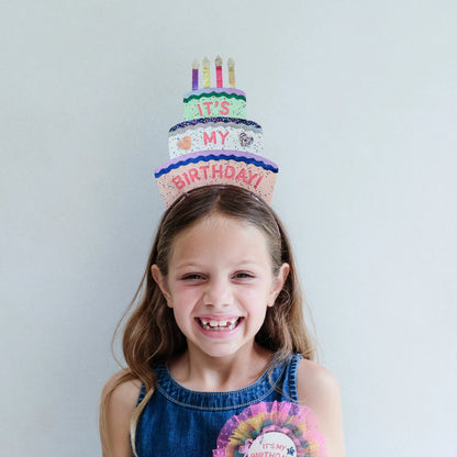 Bambina che indossa il cerchietto compleanno Mimi & Lula Birthday Cake Headdress durante la festa
