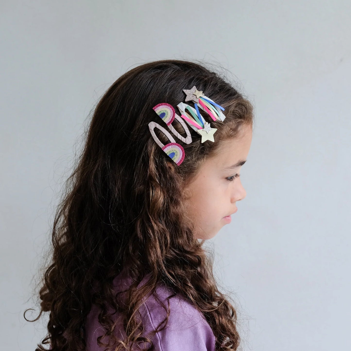 Bambina che indossa i fermagli capelli Mimi & Lula Disco Over the Rainbow con arcobaleni e stelle