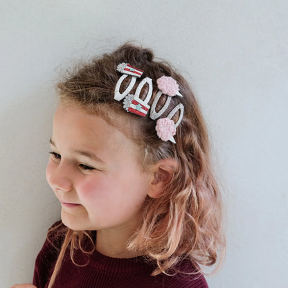 Bambina che indossa i fermagli capelli Mimi & Lula Popcorn & Candyfloss con design golosi e scintillanti