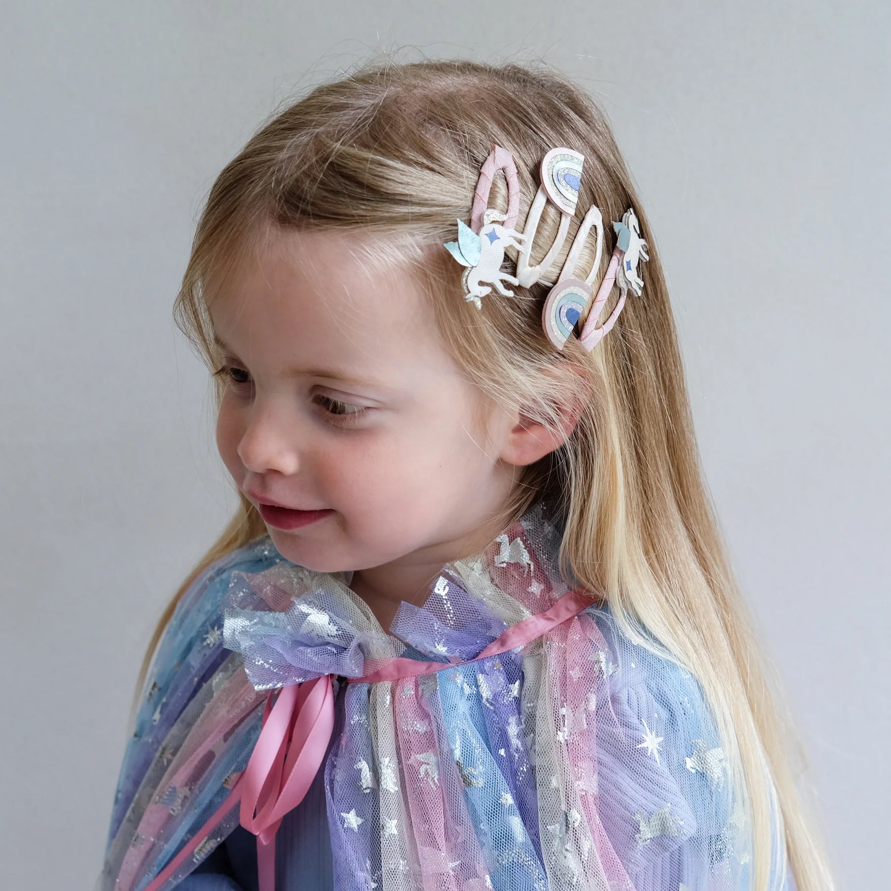 Bambina che indossa i fermagli capelli Mimi & Lula unicorno alato e arcobaleno
