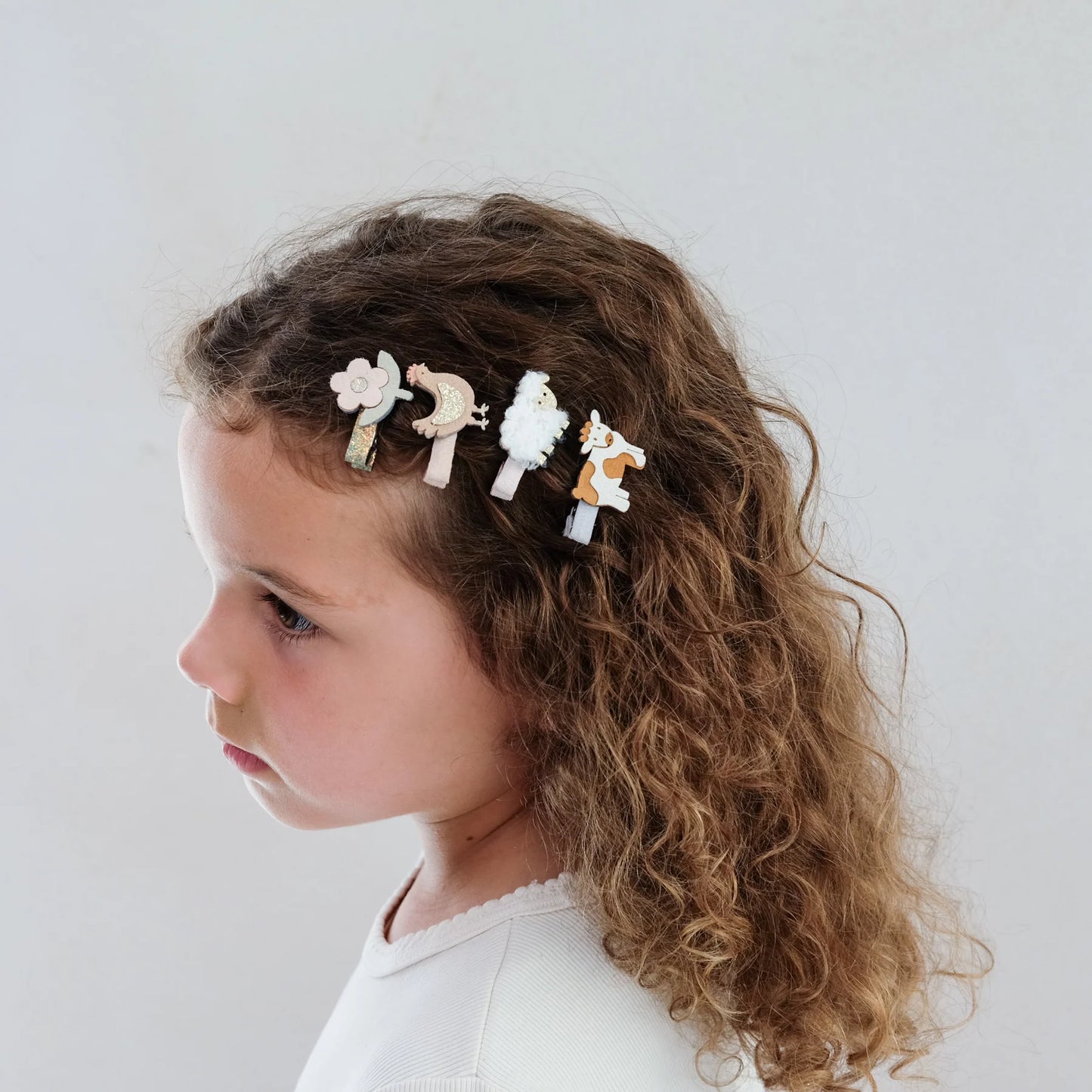 Bambina che indossa i fermagli capelli Mimi & Lula a tema animali della fattoria