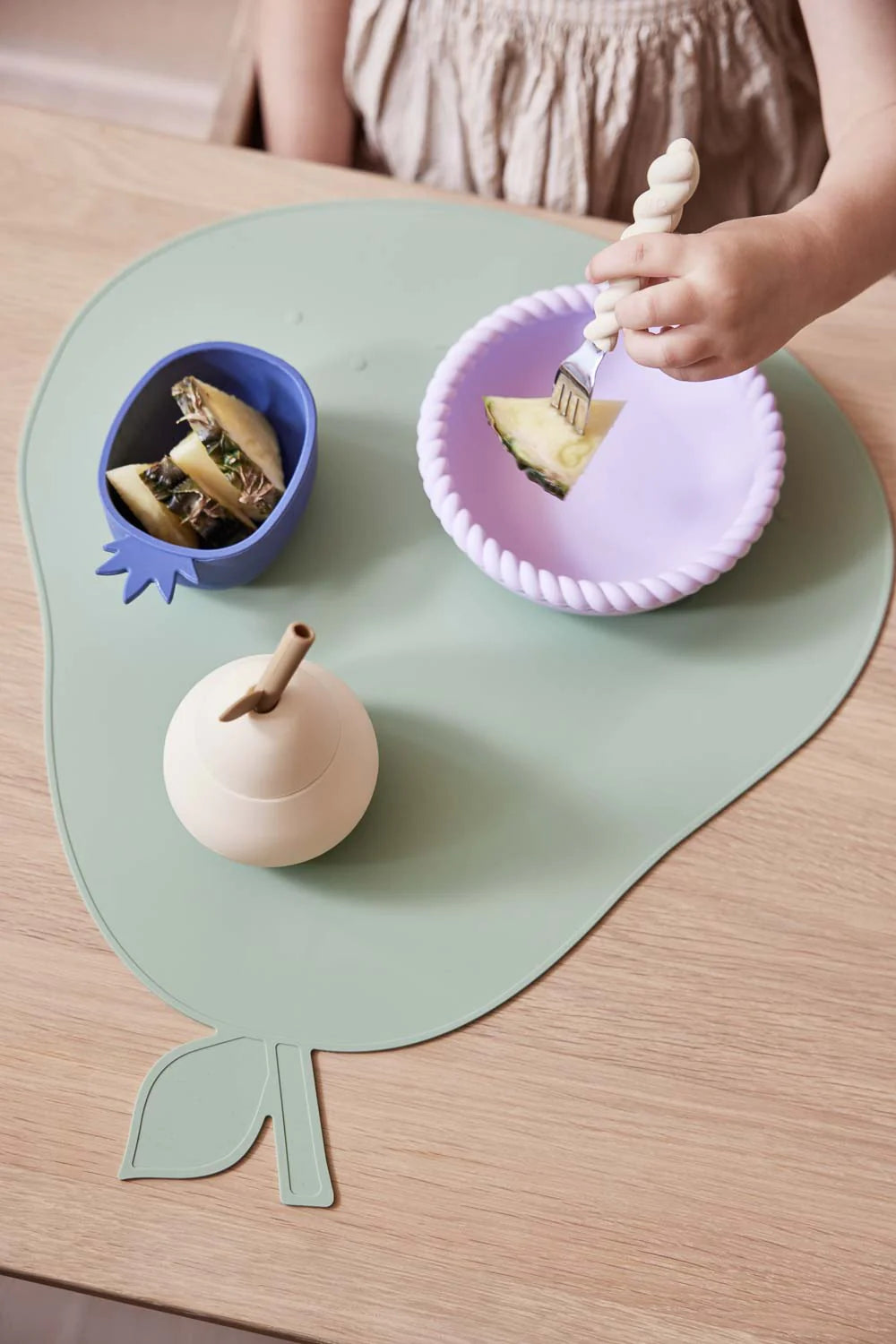 Bambino a tavola con tovaglietta pera OYOY MINI durante il pasto