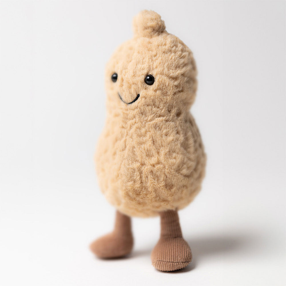 Peluche Amuseables Peanut Jellycat in posizione eretta, con capelli spettinati, occhi scintillanti e stivaletti in corda marrone