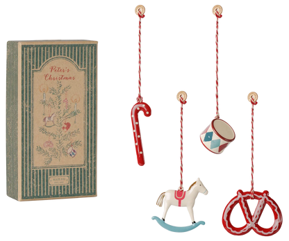 Set di 4 ornamenti natalizi Maileg Peter's Christmas in metallo con tamburo, canna di zucchero, pretzel e cavallo a dondolo in confezione regalo illustrata.