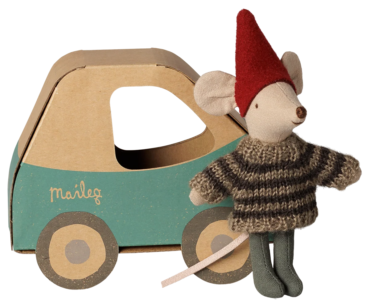 Topino Natalizio Maileg Fratellino con cappellino rosso e maglione lavorato a maglia accanto alla scatola a forma di automobile vintage.