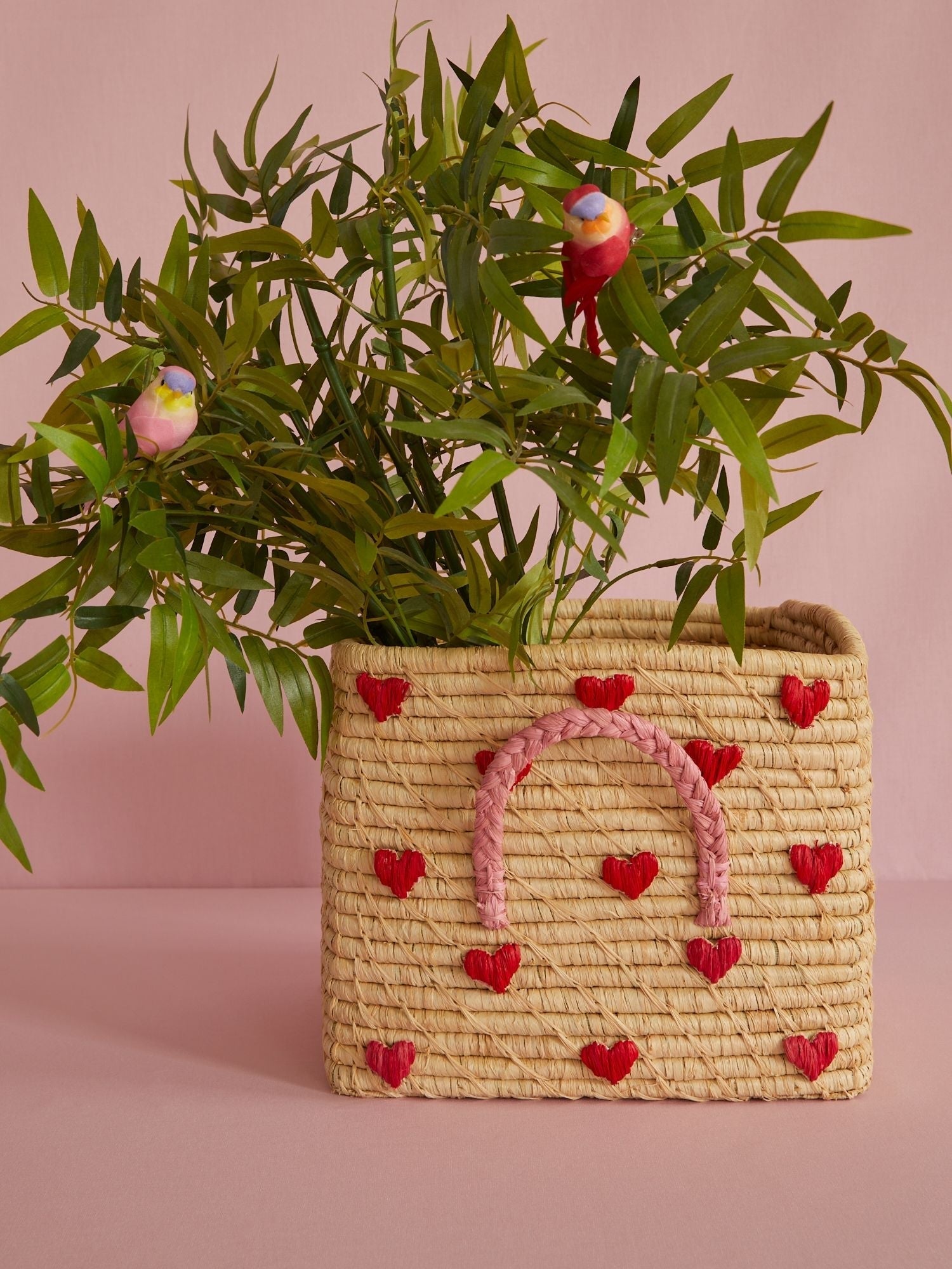 Cesto Rice in rafia intrecciata con cuori colorati usato come porta vaso decorativo in cameretta o soggiorno
